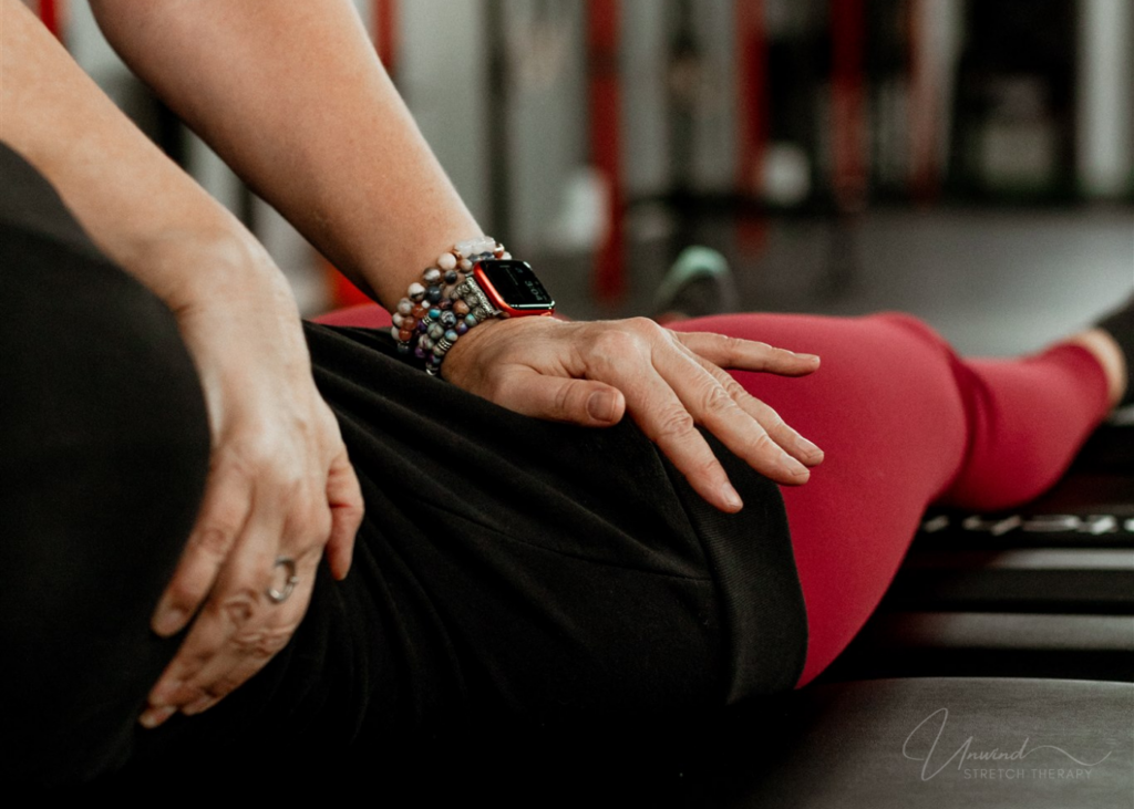 Hana Bland using gentle hand placement during a recovery-focused Fascia Stretch Therapy™ session.